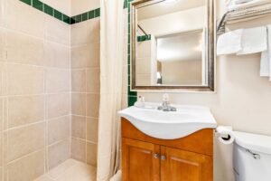 Shower with shower curtain, vanity unit, mirror, towel shelf and rail with towels