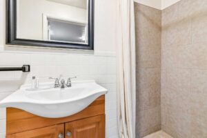 Shower with shower curtain, vanity unit, mirror