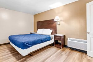 king bed, night stands, wall bedside lamp, laminate flooring